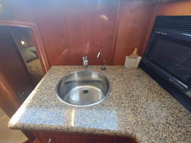 Slide: The Image of 2004 Carver 366 Motor Yacht kitchen with granite countertop and stainless steel sink. - 13