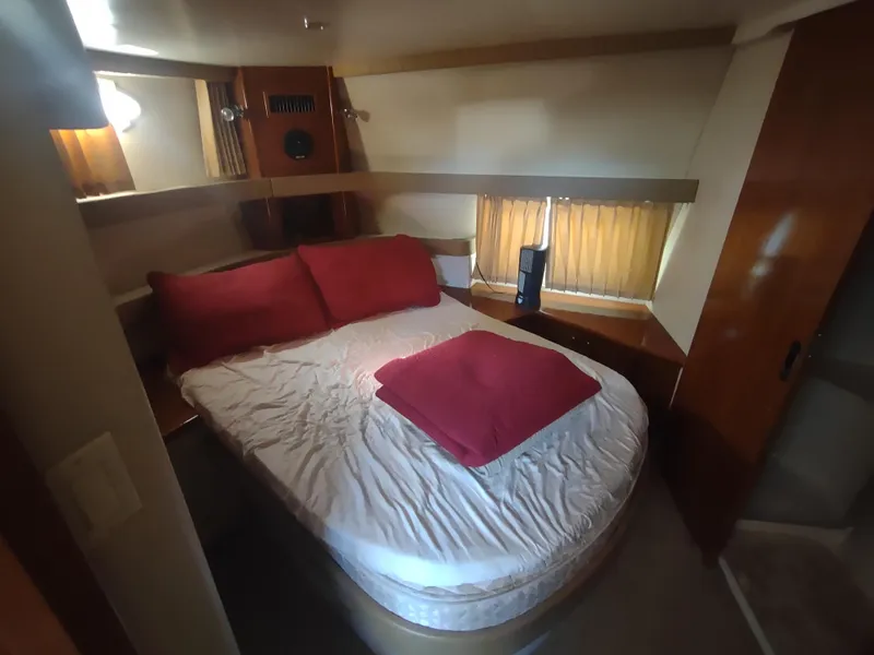 Slide: The Image of Cozy bedroom in 2004 Carver 366 Motor Yacht with red bedding and wood accents. - 26