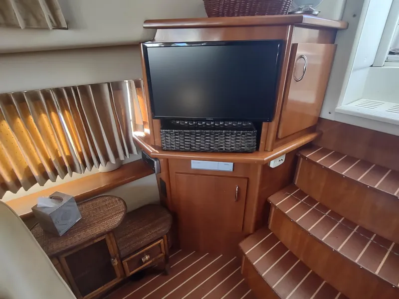 Slide: The Image of Interior of 2004 Carver 366 Motor Yacht with TV, wicker basket, and wooden stairs. - 9