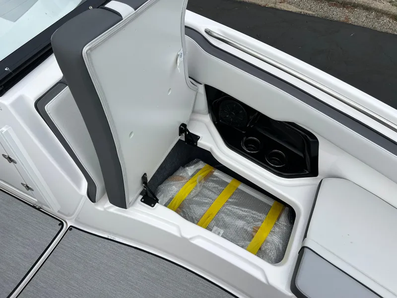 Slide: The Image of 2025 Yamaha AR250 boat storage compartment with open seat and visible interior. - 17