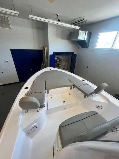 Slide: The Image of 2025 Sportsman 227 MASTERS boat interior with seating in a showroom. - 2