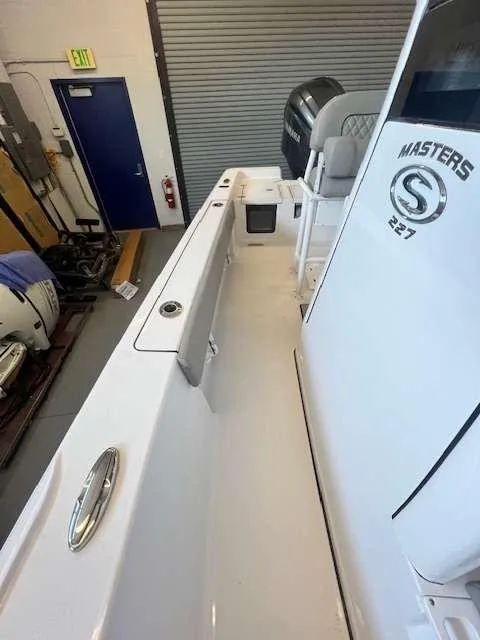 Slide: The Image of 2025 Sportsman 227 MASTERS boat interior, featuring sleek white design and seating area. - 5