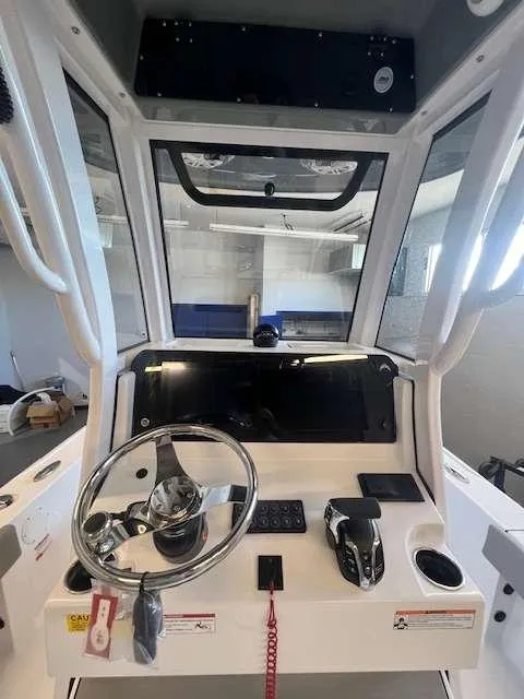 Slide: The Image of 2025 Sportsman 227 MASTERS boat console with steering wheel and controls. - 6