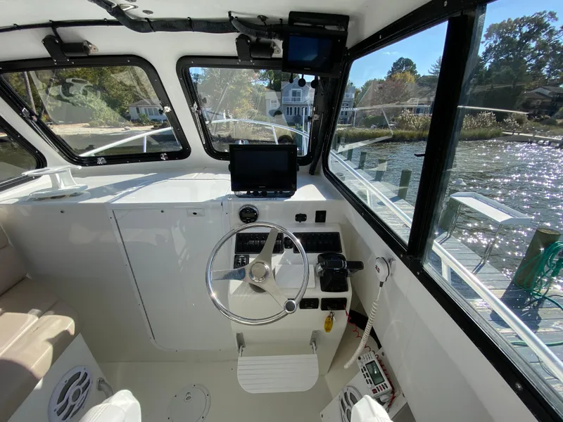 Slide: The Image of Interior view of 2018 Judge 27 Chesapeake XL boat cockpit with steering wheel and navigation equipment. - 21