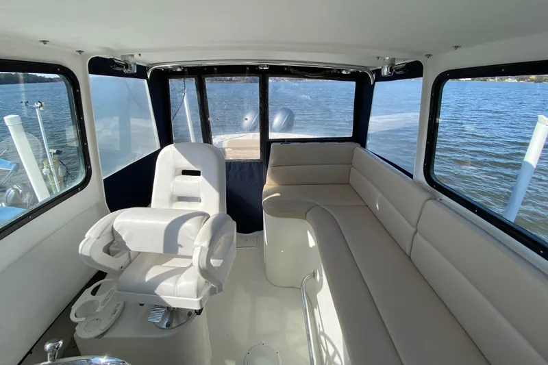 Slide: The Image of Interior of 2018 Judge 27 Chesapeake XL boat with seating and helm, overlooking water. - 23
