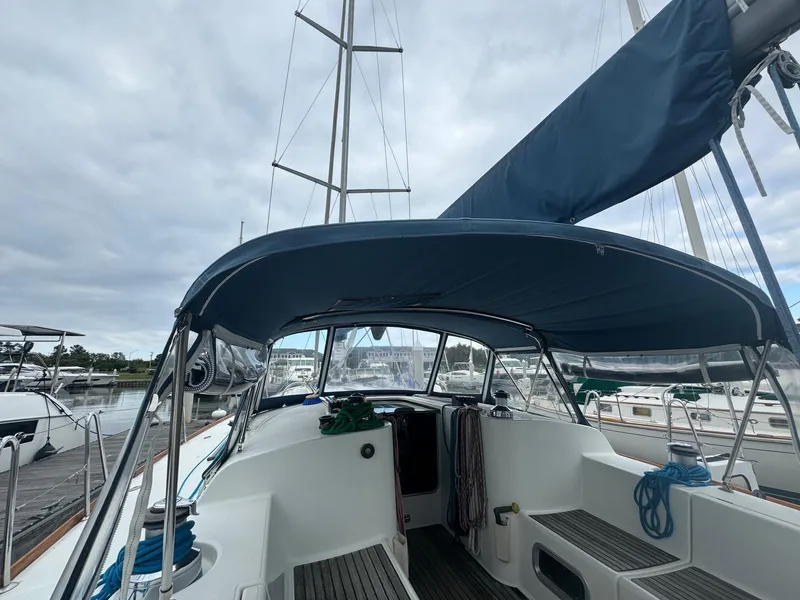 Slide: The Image of Beneteau First 47.7 sailboat cockpit, 2004 model, docked with blue canopy and rigging. - 12