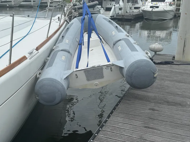 Slide: The Image of Inflatable dinghy docked beside a 2004 Beneteau First 47.7 sailboat. - 15