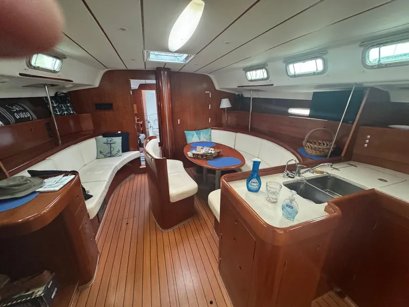 Slide: The Image of Interior of 2004 Beneteau First 47.7 yacht with wood finish and white seating. - 2
