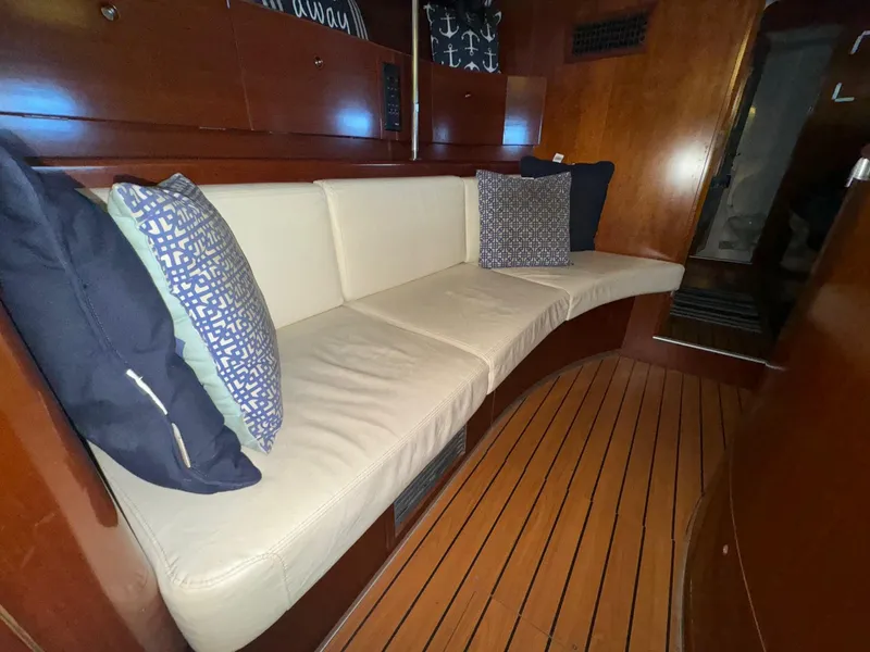 Slide: The Image of Luxurious interior of 2004 Beneteau First 47.7 yacht with cushioned seating and wooden flooring. - 24