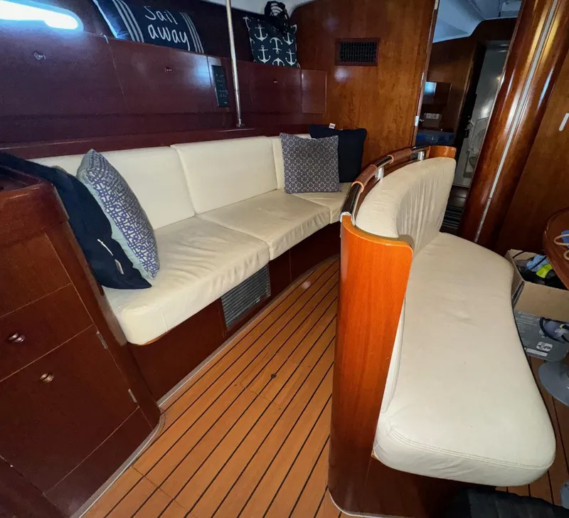 Slide: The Image of Interior of 2004 Beneteau First 47.7 yacht with wooden finish and cushioned seating. - 25