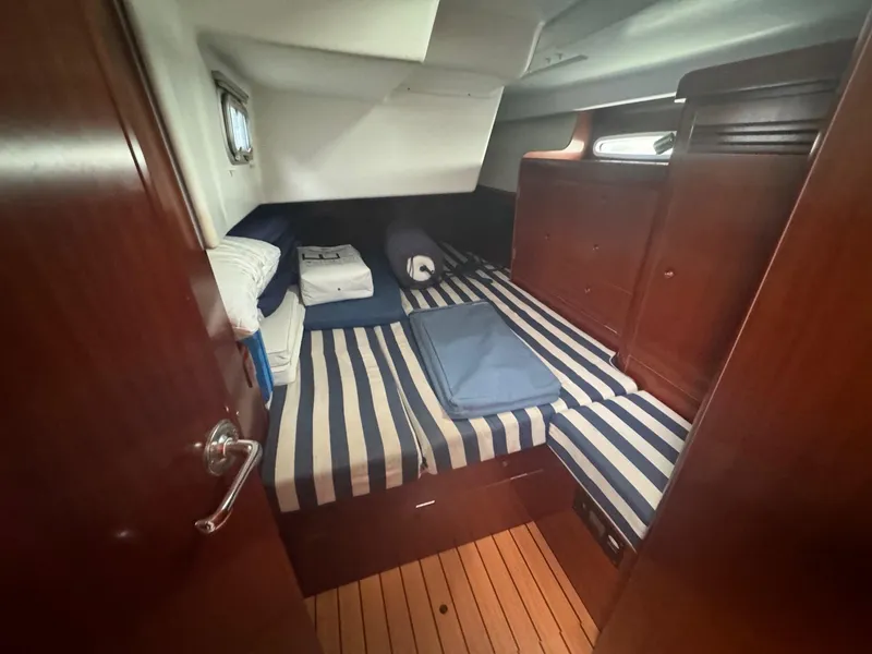 Slide: The Image of Cozy cabin interior of 2004 Beneteau First 47.7 with striped bedding and wooden finishes. - 28