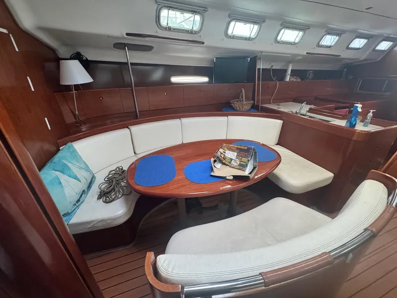 Slide: The Image of Interior of 2004 Beneteau First 47.7 yacht with cozy seating and dining area. - 3