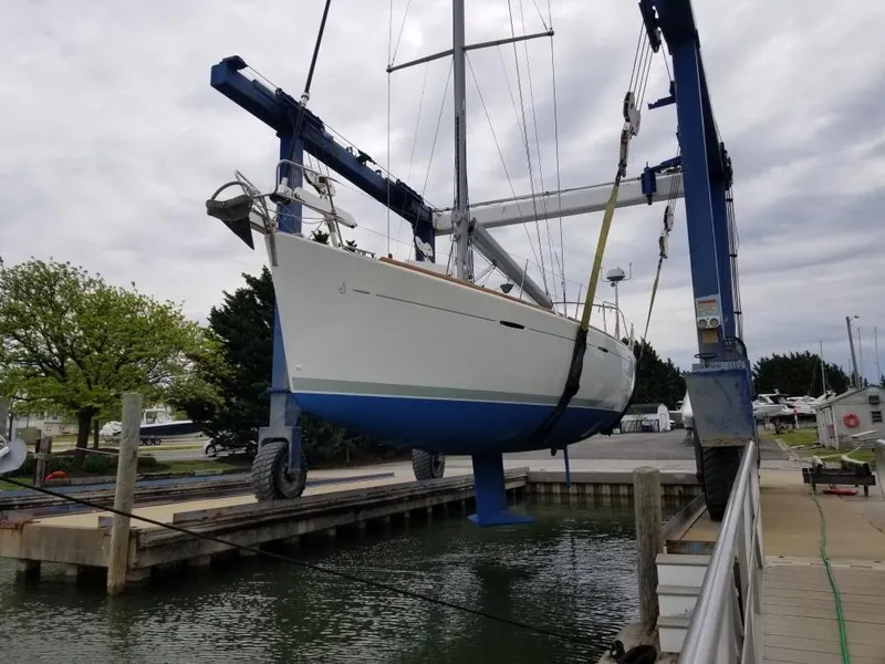 Slide: The Image of Beneteau First 47.7 sailboat, 2004 model, being lifted at a marina. - 31