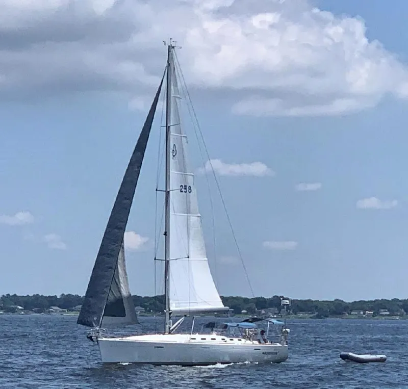 Slide: The Image of 2004 Beneteau First 47.7 sailboat on open water under a partly cloudy sky. - 4