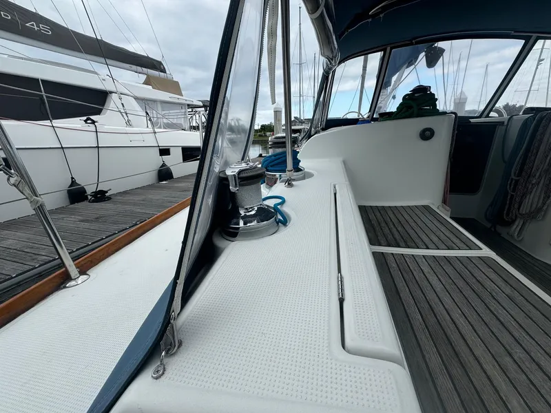 Slide: The Image of Beneteau First 47.7 sailboat deck, 2004 model, docked at marina with visible winch and ropes. - 8