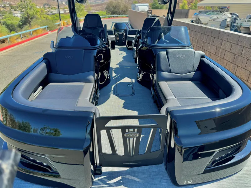 Slide: The Image of 2024 Manitou 23 XT RFXW pontoon boat with sleek black seating and modern design. - 11