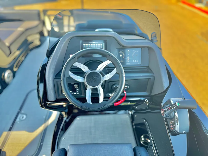 Slide: The Image of 2024 Manitou 23 XT RFXW boat dashboard with steering wheel and control panel. - 22