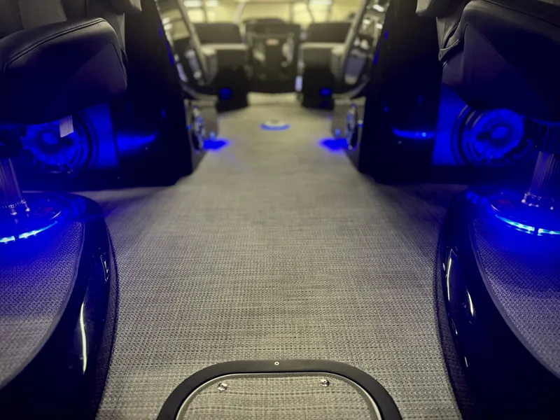 Slide: The Image of 2024 Manitou 23 XT RFXW interior with blue LED lighting and plush carpet flooring. - 26