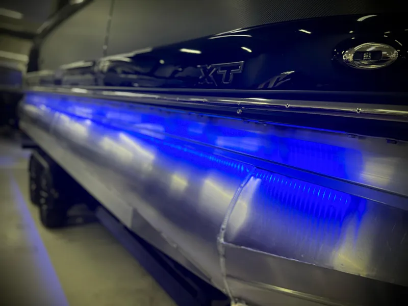 Slide: The Image of 2024 Manitou 23 XT RFXW boat with blue LED lighting. - 28