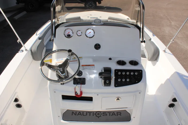 Slide: The Image of 2025 NauticStar 211 Hybrid boat dashboard with steering wheel and gauges. - 15