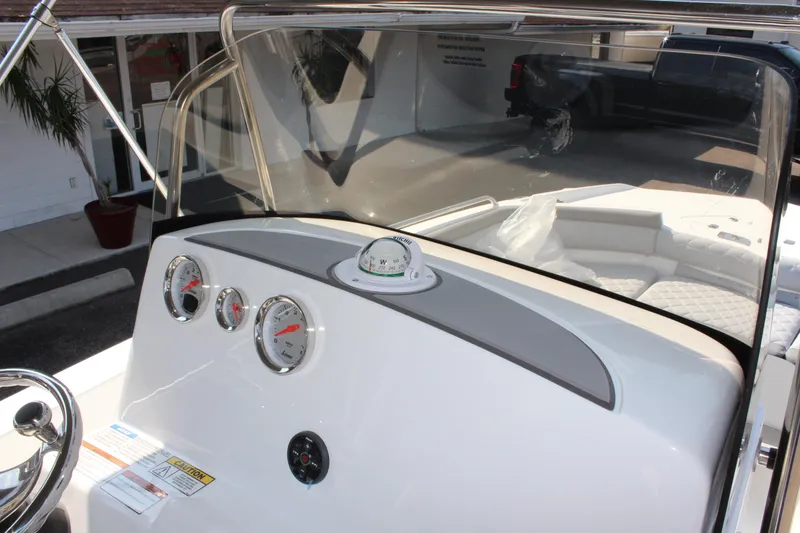 Slide: The Image of 2025 NauticStar 211 Hybrid boat dashboard with gauges and steering wheel. - 17
