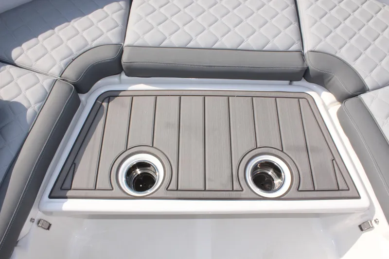 Slide: The Image of 2025 NauticStar 211 Hybrid boat interior with quilted gray seating and dual cup holders. - 24