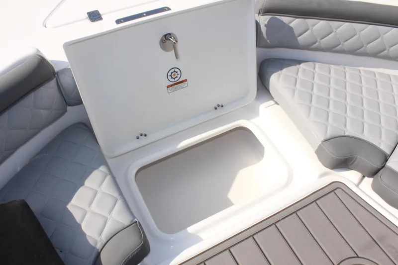 Slide: The Image of 2025 NauticStar 211 Hybrid boat interior with storage compartment and cushioned seating. - 25