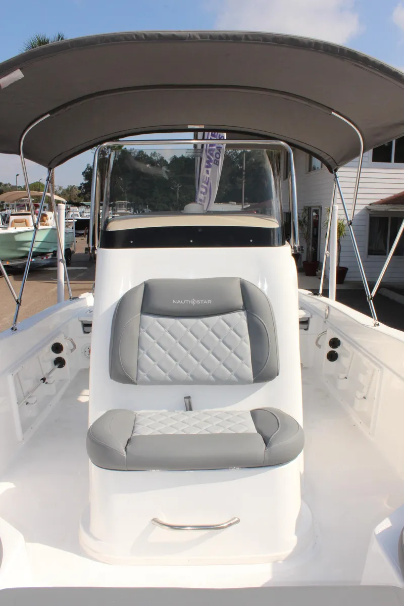 Slide: The Image of 2025 NauticStar 211 Hybrid boat with cushioned seating and canopy. - 27