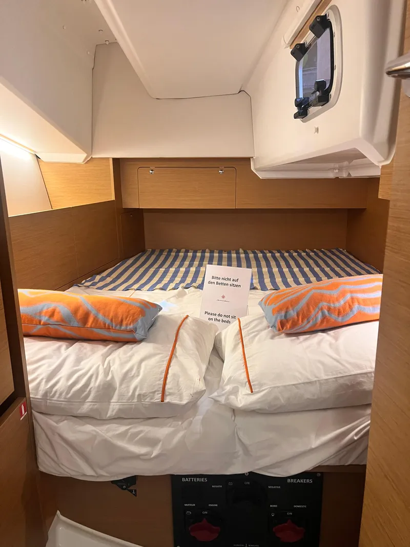 Slide: The Image of Cozy cabin interior of 2026 Jeanneau Sun Odyssey 350 sailboat with striped bedding. - 12