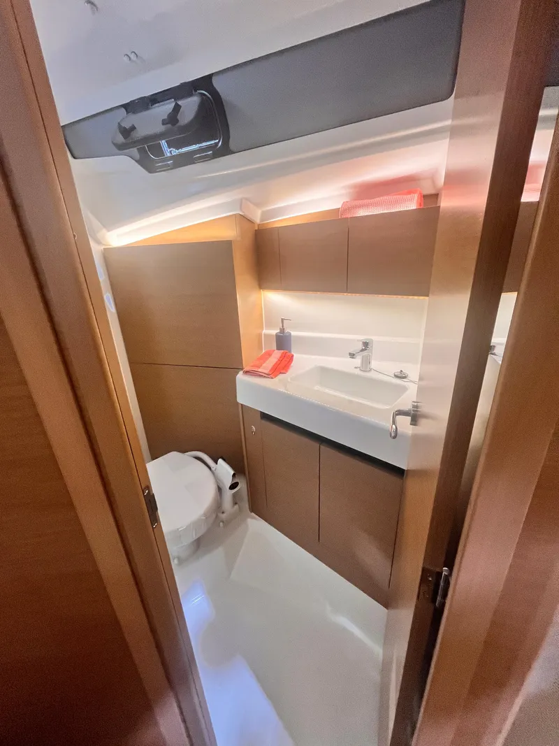 Slide: The Image of 2026 Jeanneau Sun Odyssey 350 yacht bathroom with modern fixtures and wooden cabinetry. - 13