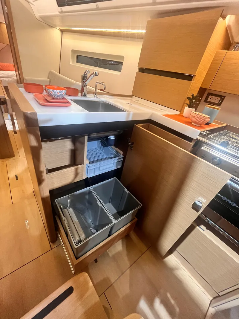 Slide: The Image of Modern kitchen interior of 2026 Jeanneau Sun Odyssey 350 yacht, featuring sleek cabinetry and appliances. - 16
