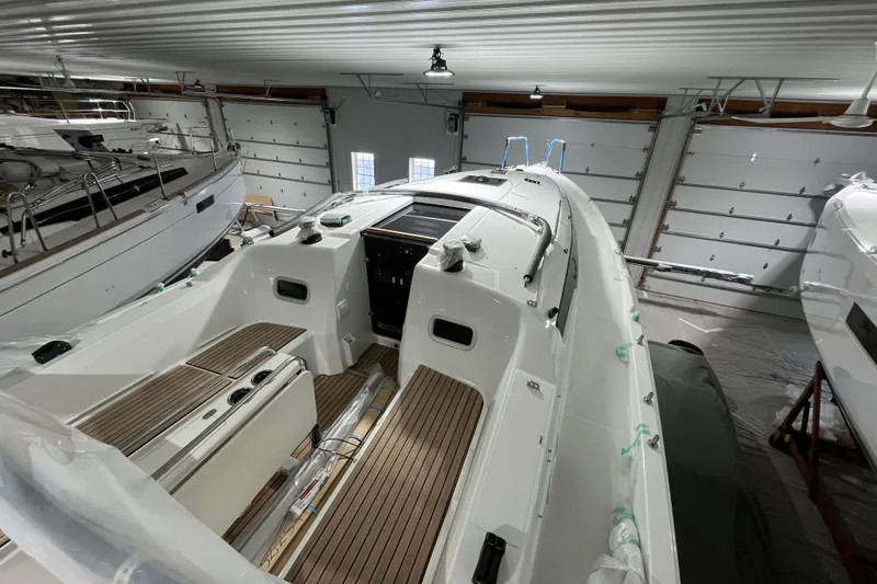 Slide: The Image of 2026 Jeanneau Sun Odyssey 350 sailboat in indoor storage, showcasing sleek design and spacious deck. - 2