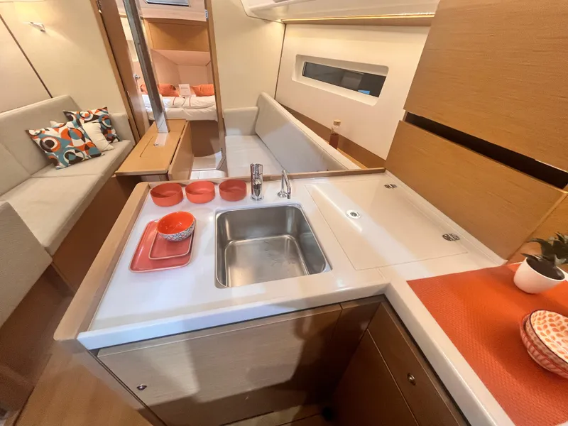 Slide: The Image of Modern Jeanneau Sun Odyssey 350 yacht interior with kitchen, sink, and cozy seating area, 2026 model. - 21