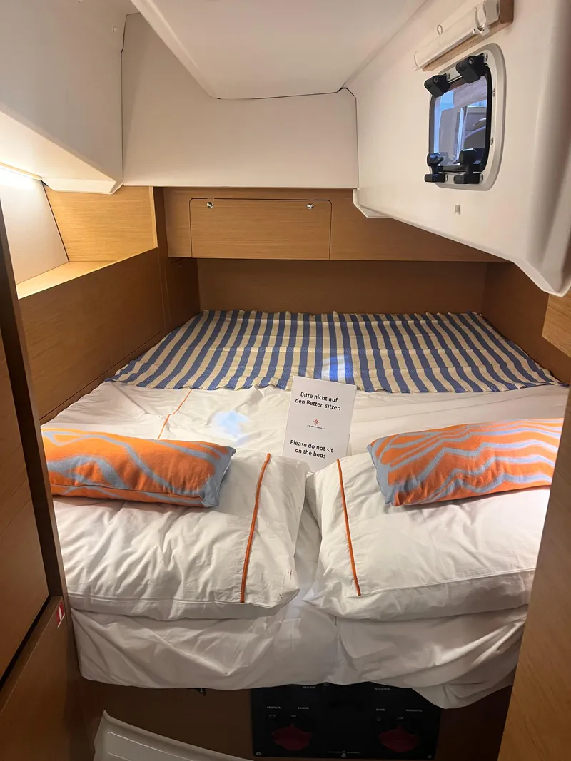 Slide: The Image of Cozy cabin interior of 2026 Jeanneau Sun Odyssey 350 sailboat with striped bedding. - 33