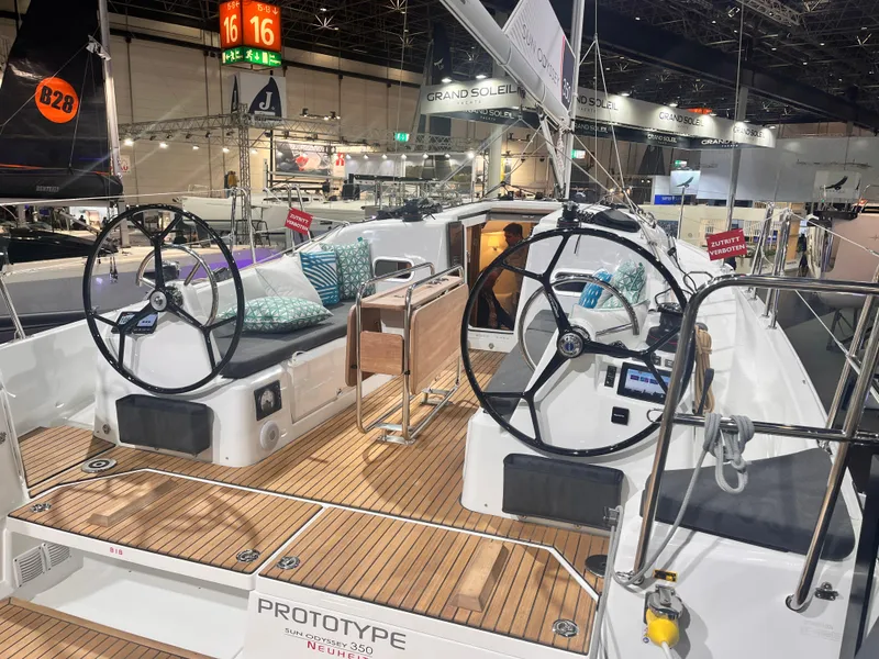 Slide: The Image of 2026 Jeanneau Sun Odyssey 350 sailboat prototype with dual steering wheels at a boat show. - 7