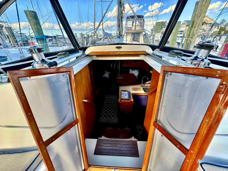 Slide: The Image of Interior view of 2002 Hunter 356 sailboat cabin with open wooden doors. - 12