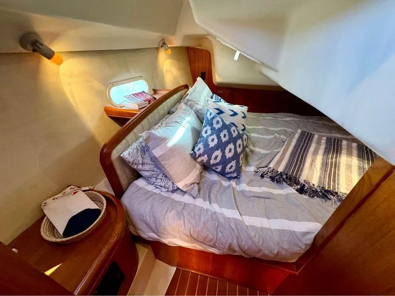 Slide: The Image of Cozy cabin interior of 2002 Hunter 356 sailboat with bed and decorative pillows. - 15