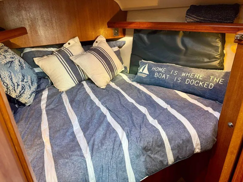 Slide: The Image of Cozy cabin interior of 2002 Hunter 356 sailboat with striped bedding and nautical decor. - 17