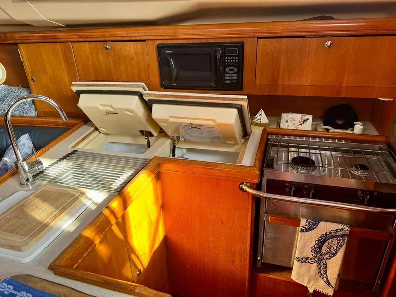 Slide: The Image of 2002 Hunter 356 yacht kitchen with stove, sink, and microwave. - 18