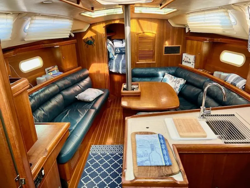 Slide: The Image of Interior of 2002 Hunter 356 sailboat with wood finish and cozy seating area. - 2