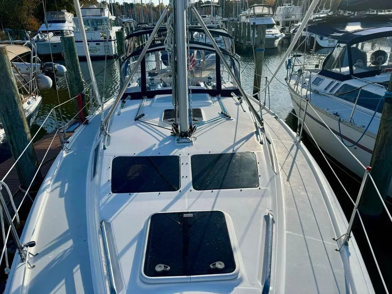 Slide: The Image of 2002 Hunter 356 sailboat docked at marina, surrounded by other boats. - 21