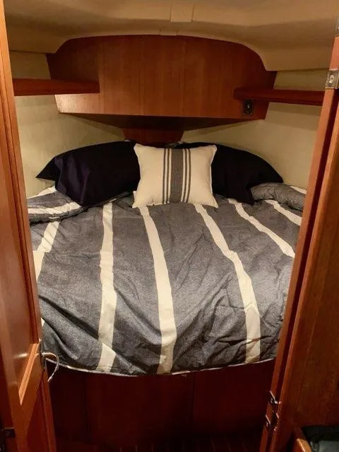 Slide: The Image of Cozy cabin bedroom in 2002 Hunter 356 sailboat with striped bedding. - 3