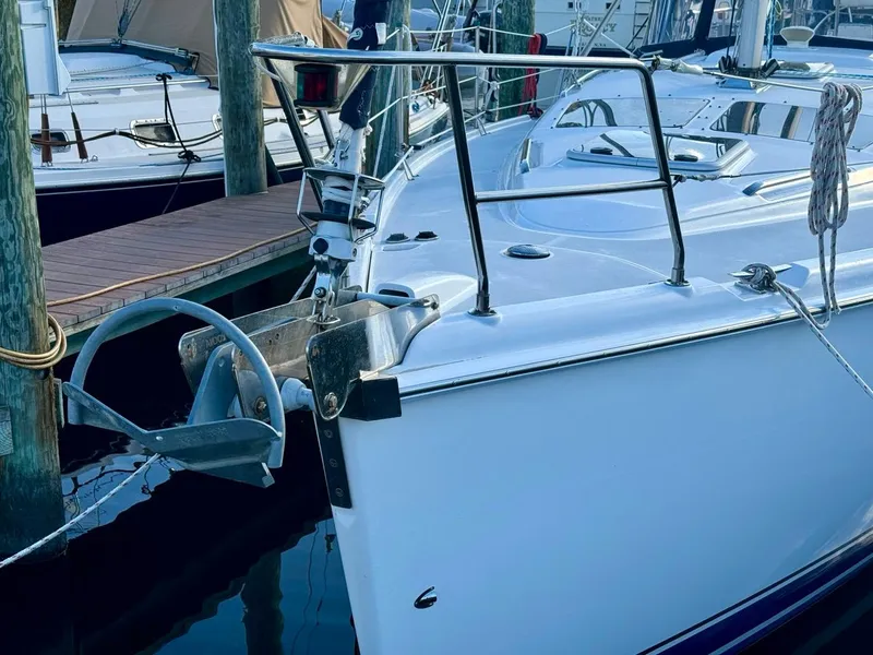 Slide: The Image of 2002 Hunter 356 sailboat docked at marina, featuring sleek white hull and anchor. - 30