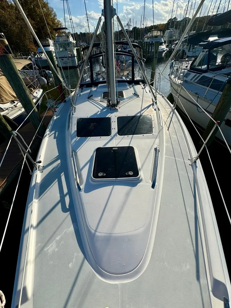 Slide: The Image of 2002 Hunter 356 sailboat docked at marina, showcasing deck and rigging. - 36