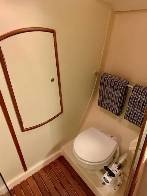 Slide: The Image of 2002 Hunter 356 boat bathroom with toilet, wooden floor, and towel rack. - 4