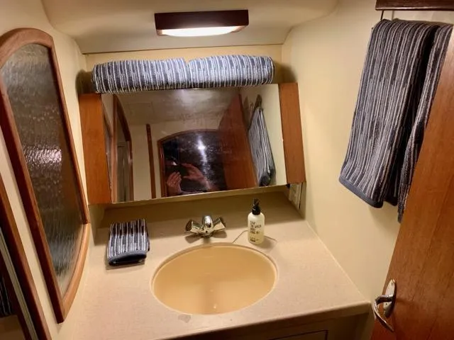Slide: The Image of Compact bathroom in 2002 Hunter 356 yacht with sink, mirror, and striped towels. - 5