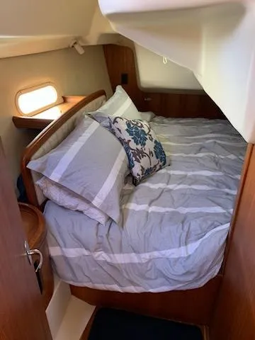 Slide: The Image of Cozy cabin interior of 2002 Hunter 356 sailboat with striped bedding and floral pillow. - 6