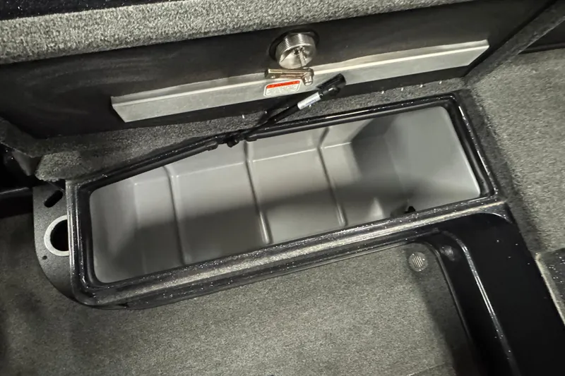 Slide: The Image of Open storage compartment in 2024 Nitro ZV20 boat, featuring secure latch and carpeted interior. - 12