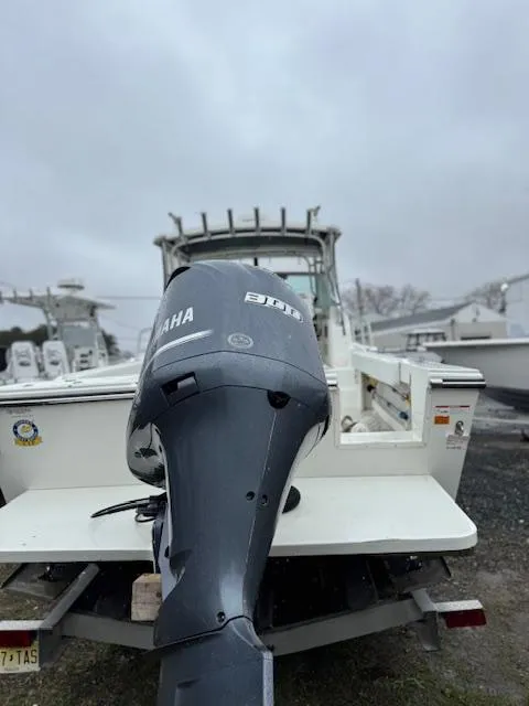 Slide: The Image of 2015 Parker 2510 XLD boat with Yamaha outboard motor, docked on a cloudy day. - 10