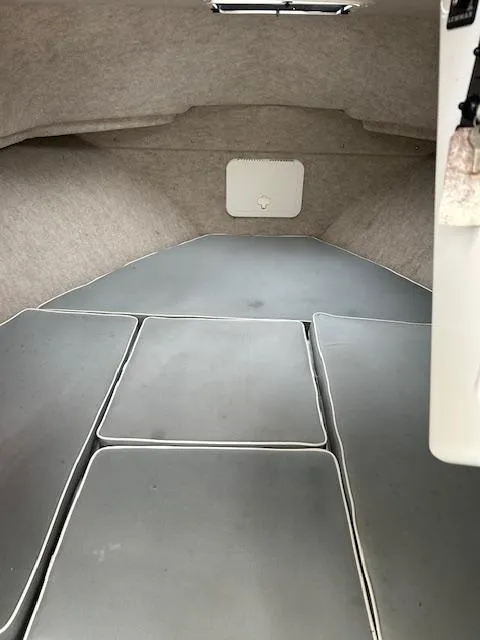 Slide: The Image of Interior cabin of a 2015 Parker 2510 XLD boat, featuring cushioned seating. - 15